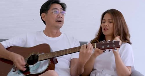 Couple Sings and Plays Guitar Together at Home