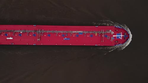 Aerial view oil tanker is floating at rivering for unloading in port. Business import export oil and