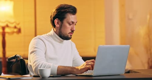 Adult Typing on Laptop at Desk in Wheelchair