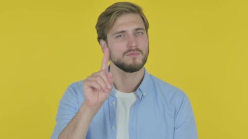 Young Man Gesturing No on Yellow Background