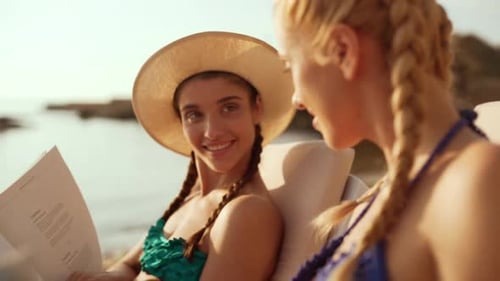 Women Relaxing in Beach Chairs Near Ocean