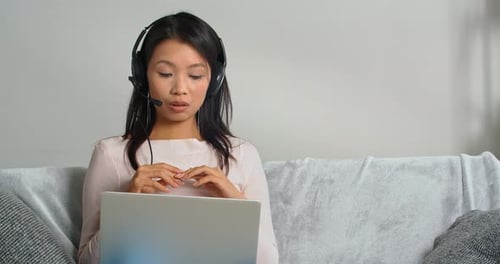 Woman Talking on Laptop with Headset at Home