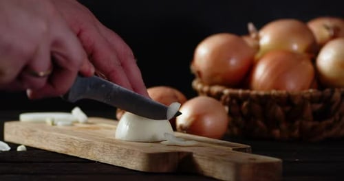 Mit Männerhänden geschnittenes Zwiebelmesser am Halbring.