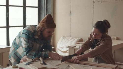 Male and Female Joiners Working in Carpentry Workshop