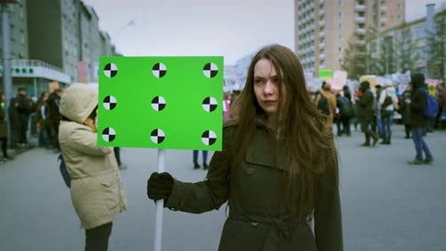 Banner in a Crowd of People Copy Space Text. Girl with a Blank Poster on Strike.