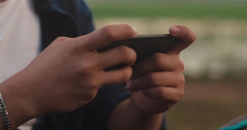 Young asia campers guy use mobile technology phone with internet connection near seaside.