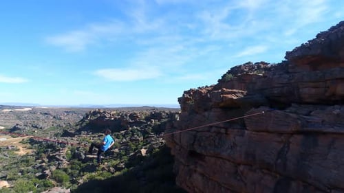 Adult Walking a Tightrope on a Mountain Ridge