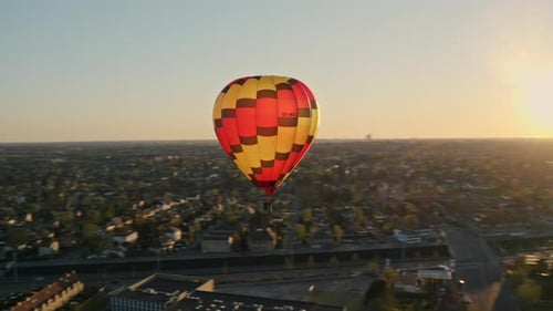 Hot Air Balloon Flying Over City at Sunrise