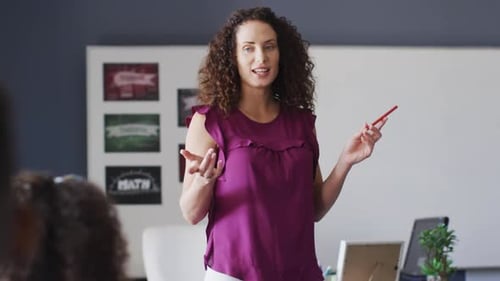 Video of caucasian female school teacher and diverse school children studying in classroom