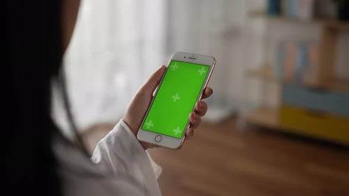 Closeup of hand woman holding smartphone with green screen