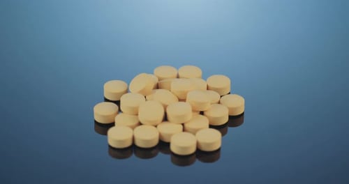 Close-up of Tan Pills on Reflective Surface