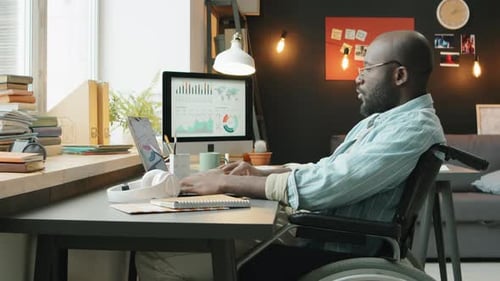 Homme afro-américain handicapé travaillant à domicile