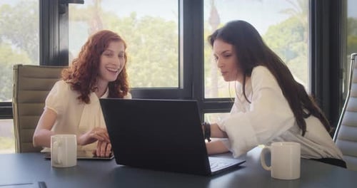 Women Collaborating on Laptop in Office