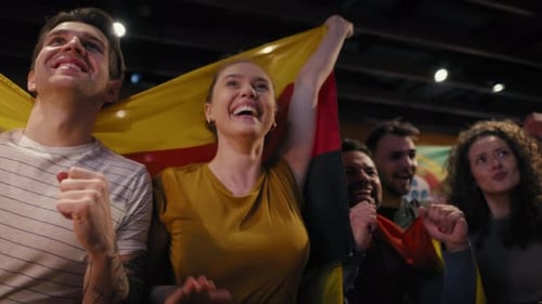 Group of friends cheering to soccer match in the pub. Shot with RED helium camera in 8K.