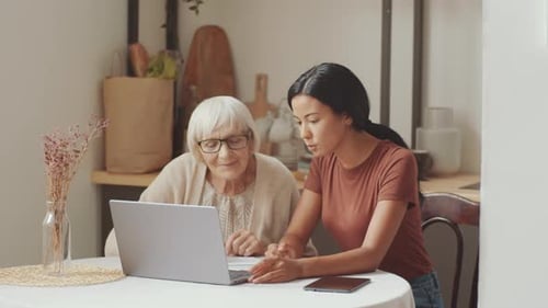 Senior Woman Learning Computer Skills with Younger Woman