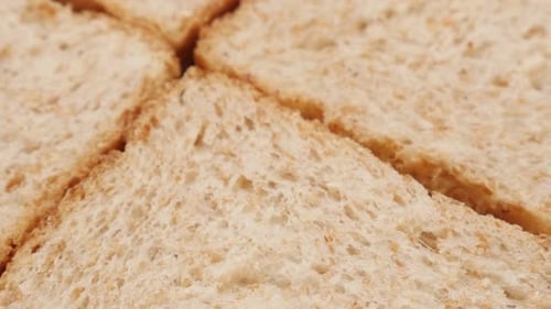 Whole grain toast bread pieces close-up tilting 4K 2160p 30fps UltraHD footage - Toasting bread co