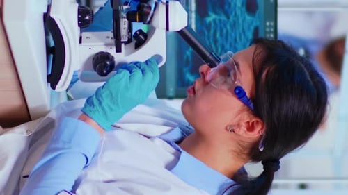 Woman Scientist Using Microscope in Lab