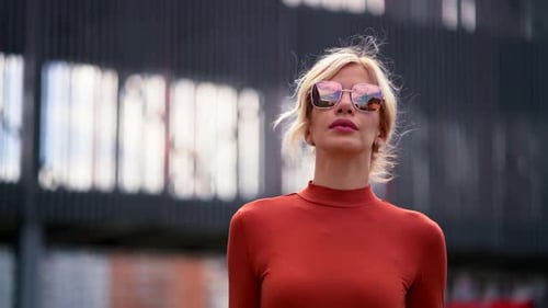 Beautiful Fashionista Lady Is Walking at City, Urban Scape, Wearing Sunglasses and Black Jacket