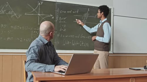 Mixed Race Student Solving Geometry Problem at Blackboard