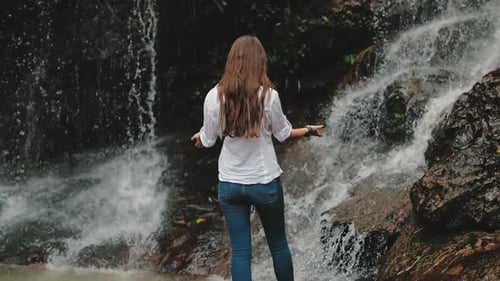Woman Enjoying Waterfall in Tropical Nature Setting