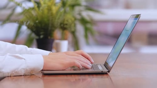 Hands Typing on Laptop Computer in Office