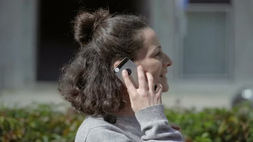 Woman Talking on Smartphone Outdoors in City