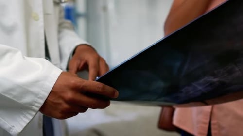 Doctor Showing X-Ray to Patient in Hospital