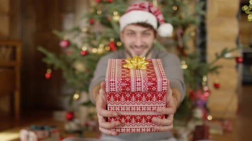 Smiling Man Giving Christmas Gift at Home
