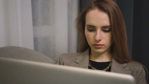 Portrait of Tired young woman finished work, using laptop looking at screen typing message