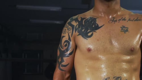 Muscular Man in Boxing Gloves Poses Shirtless