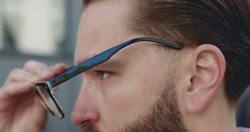 Man Putting on Glasses Close Up