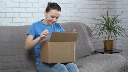 Woman Opens Box, Disappointed with Contents