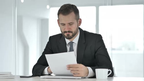 Geschäftsmann liest Dokumente, Papierkram