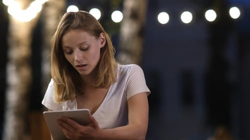 Woman Using Tablet Outside at Night