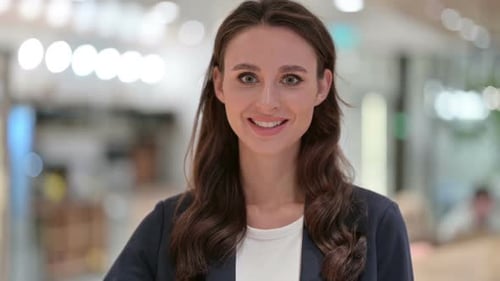 Smiling Woman Gives OK Hand Gesture in Office