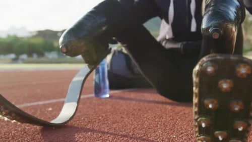 Focused Athlete Puts on Headphones on Running Track