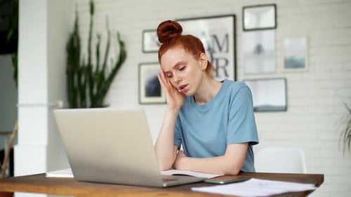 Stressed Woman Working on Laptop at Home Desk