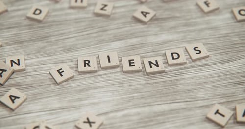 Word FRIENDS Spelled by Moving Wooden Letter Tiles