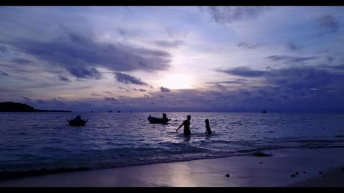 Family of two relax on beautiful coast beach journey by blue green sea with bright sandy background