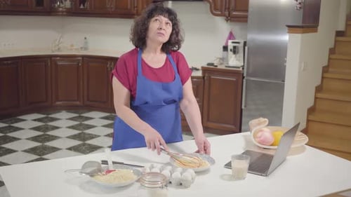Woman Whisking Ingredients in Kitchen