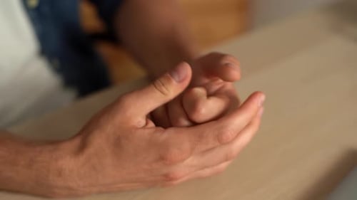 Closeup Top View Hands of Unrecognizable Nervous Young Man Snapping Fingers Sitting at Desk in Home