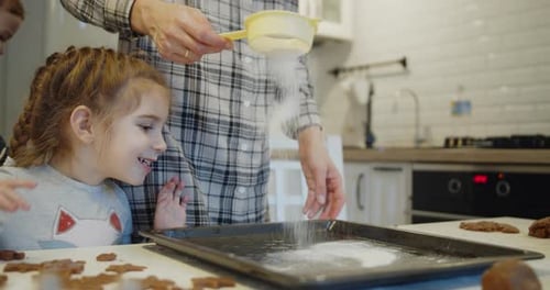 Young Mother and Daughter Having Fun Baking Cookies in the Kitchen Together