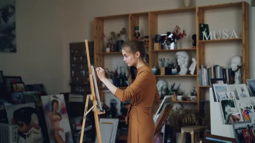 Art Student Is Working in Studio Alone Painting Picture with Oil Paints Using Brush and Palette