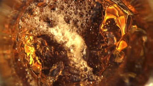 Bubbly Golden Liquid Swirling in a Glass