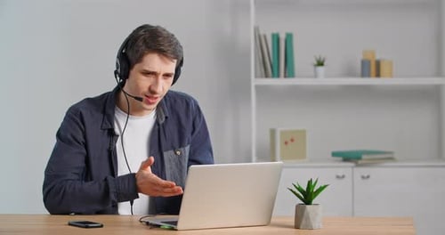 Man Talking on Headset During Online Video Call