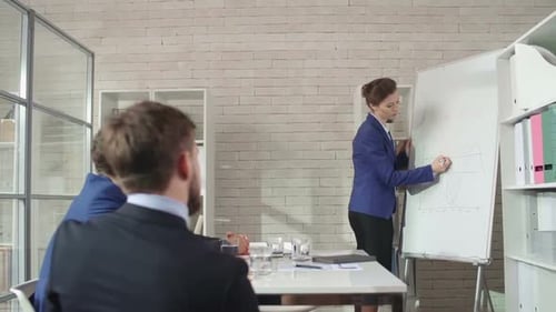 Businesswoman Giving Presentation to Colleagues in Office