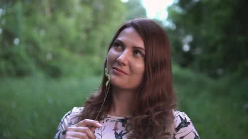 A Happy Girl is Standing in a Forest with Summer Sunny Weather