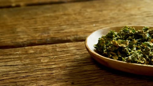 Dried herbs in plate on wooden surface 4K 4k