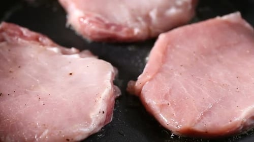 Raw Pork Pieces Sizzle in Pan with Oil