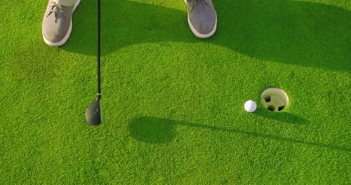 Man Play Golfing And Putting Ball In Hole. Close-up.